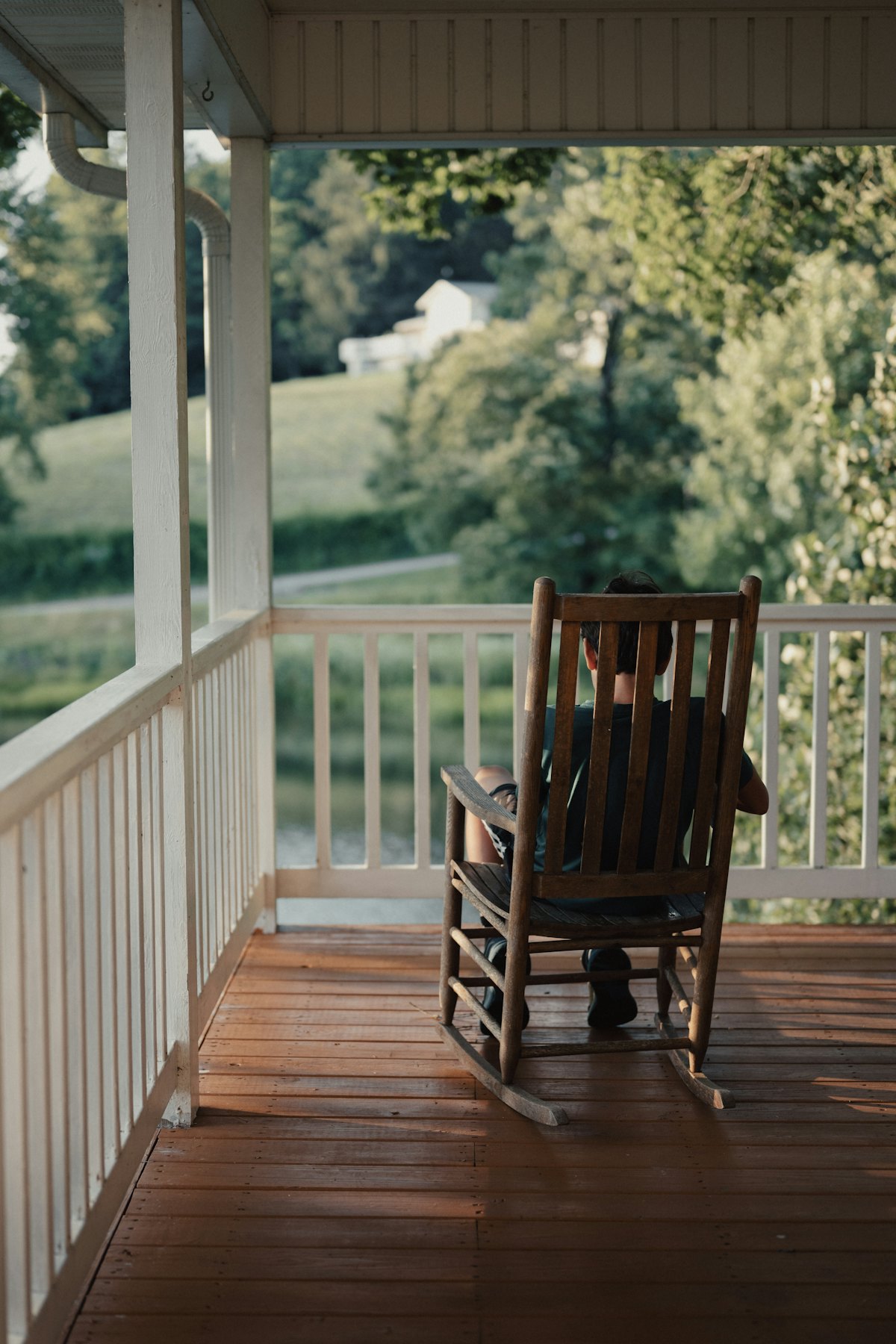 Stained wooden porch deck with white painted railings